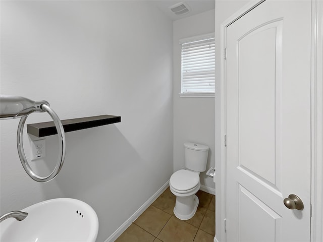 bathroom with toilet, tile patterned floors, and sink