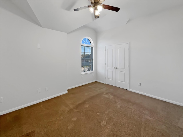 empty room featuring ceiling fan, carpet, and lofted ceiling