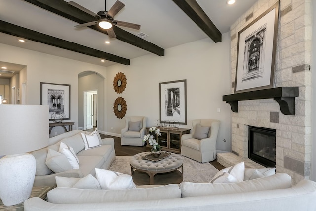 living room with beamed ceiling, ceiling fan, a fireplace, and light hardwood / wood-style flooring