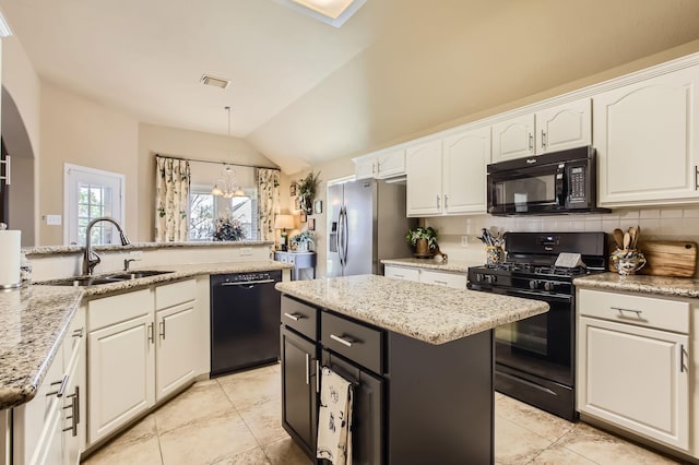 kitchen with a sink, visible vents, white cabinetry, backsplash, and black appliances