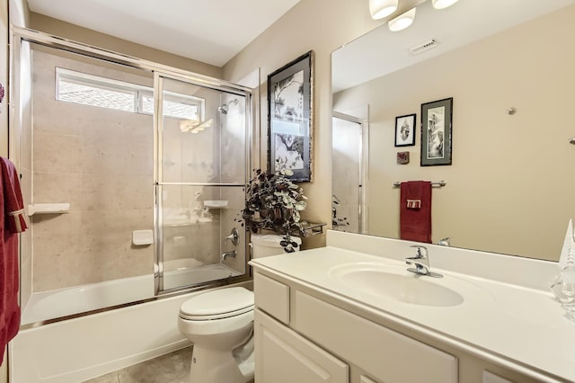 bathroom with visible vents, toilet, tile patterned flooring, combined bath / shower with glass door, and vanity