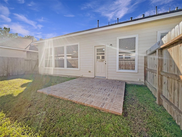 rear view of property with a yard and a patio area