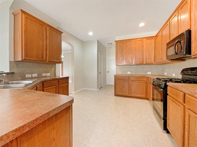 kitchen featuring black appliances, light tile patterned floors, sink, and tasteful backsplash