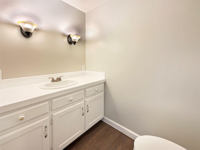 bathroom with hardwood / wood-style floors, vanity, and toilet