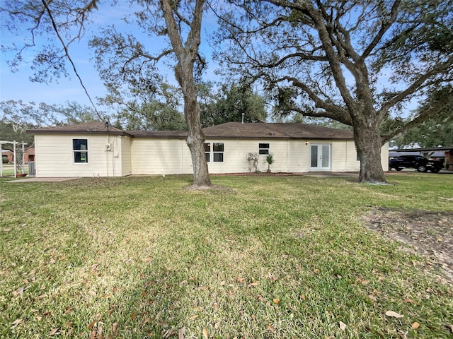 back of house with a lawn and french doors