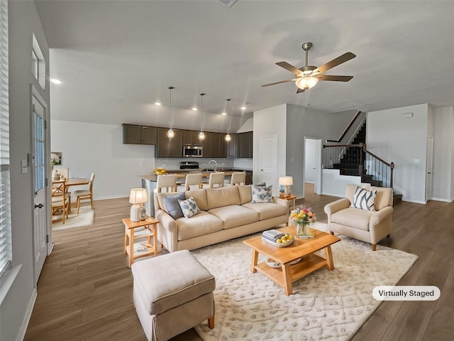 living room featuring hardwood / wood-style flooring, ceiling fan, and sink