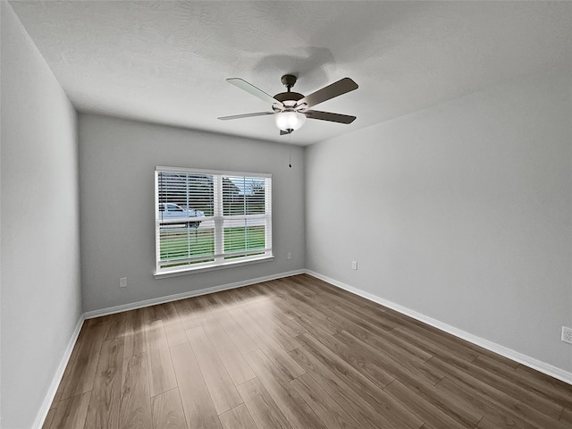 unfurnished room with ceiling fan and hardwood / wood-style flooring