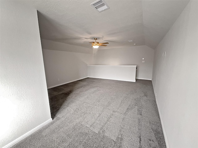 additional living space featuring carpet, ceiling fan, lofted ceiling, and a textured ceiling