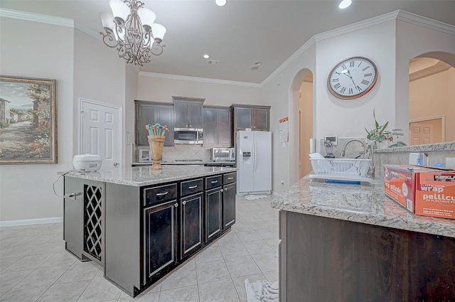 kitchen with an inviting chandelier, light tile patterned flooring, pendant lighting, crown molding, and white fridge with ice dispenser