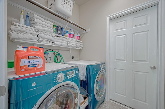 clothes washing area featuring washing machine and clothes dryer and light tile patterned floors