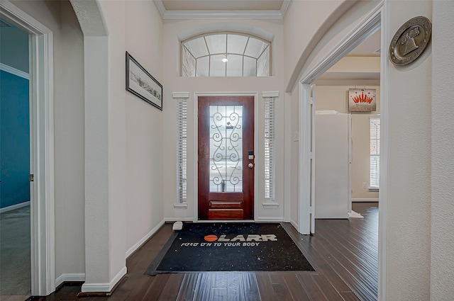 entrance foyer featuring ornamental molding and dark hardwood / wood-style flooring