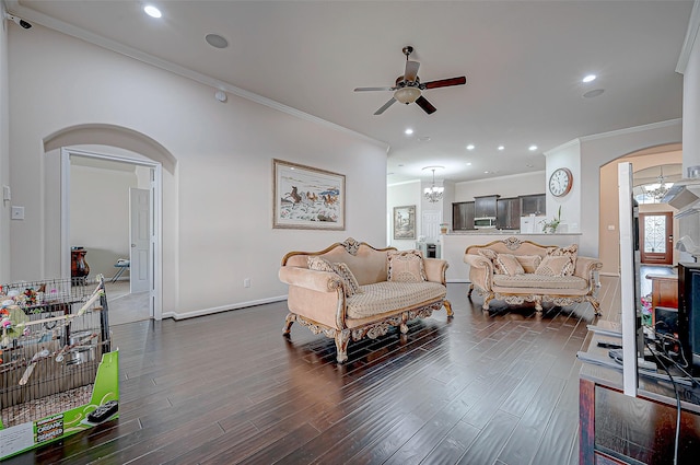 living room featuring ornamental molding, dark hardwood / wood-style flooring, and ceiling fan with notable chandelier