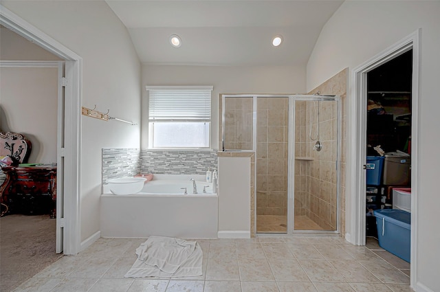 bathroom featuring decorative backsplash, vaulted ceiling, plus walk in shower, and tile patterned floors