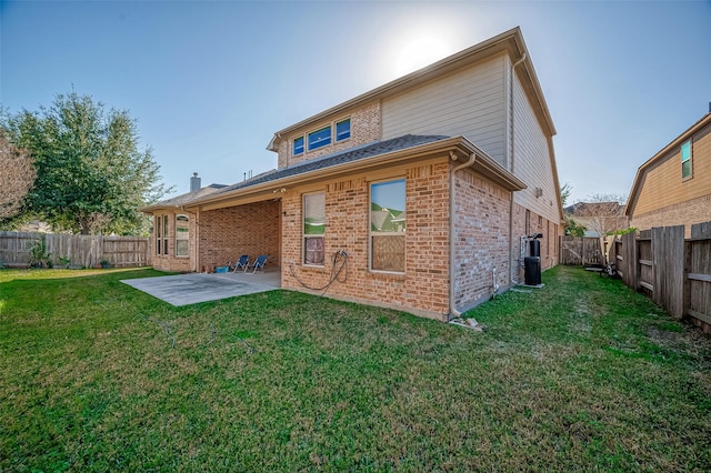 rear view of house with a lawn and a patio