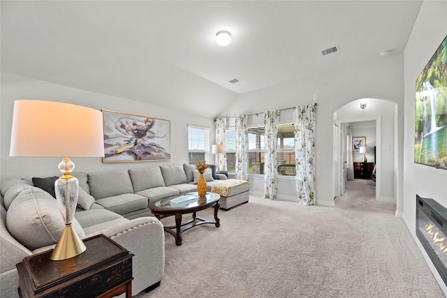 carpeted living room featuring vaulted ceiling