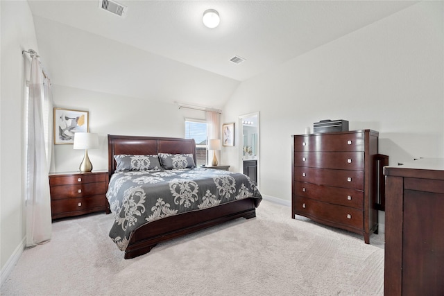 bedroom featuring light carpet, connected bathroom, and lofted ceiling