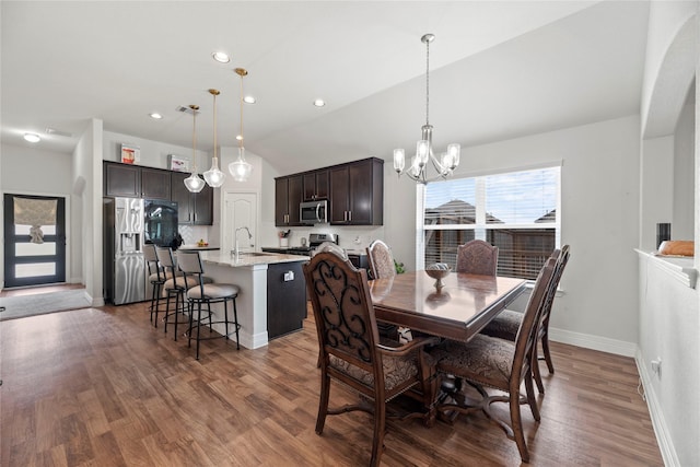 dining room featuring a notable chandelier, dark hardwood / wood-style floors, lofted ceiling, and sink