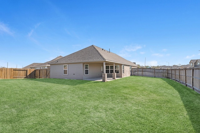 rear view of house with a patio and a lawn