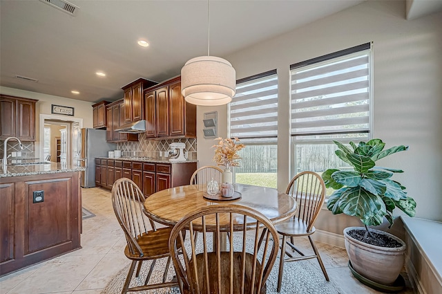 tiled dining room featuring sink