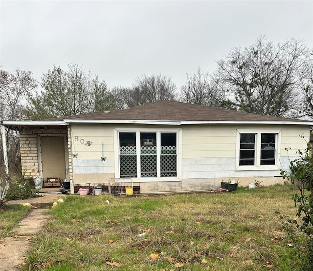 rear view of house featuring a lawn