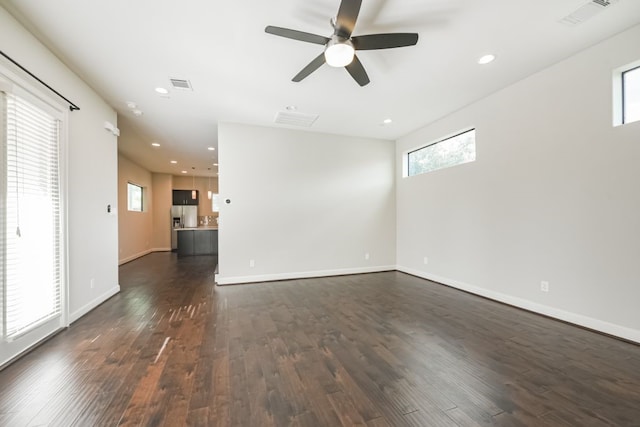 unfurnished room with a wealth of natural light, dark hardwood / wood-style flooring, and ceiling fan