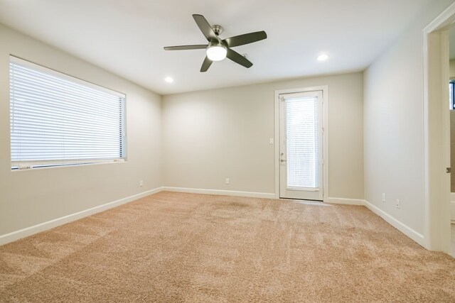 carpeted spare room featuring ceiling fan