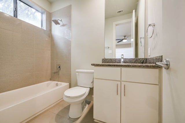 full bathroom featuring tile patterned floors, vanity, tiled shower / bath combo, ceiling fan, and toilet