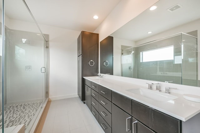 bathroom featuring a shower with door, vanity, and tile patterned flooring