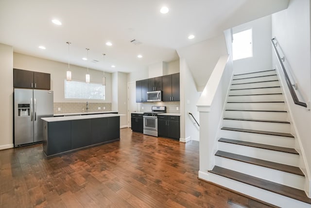 kitchen featuring appliances with stainless steel finishes, tasteful backsplash, plenty of natural light, and hanging light fixtures