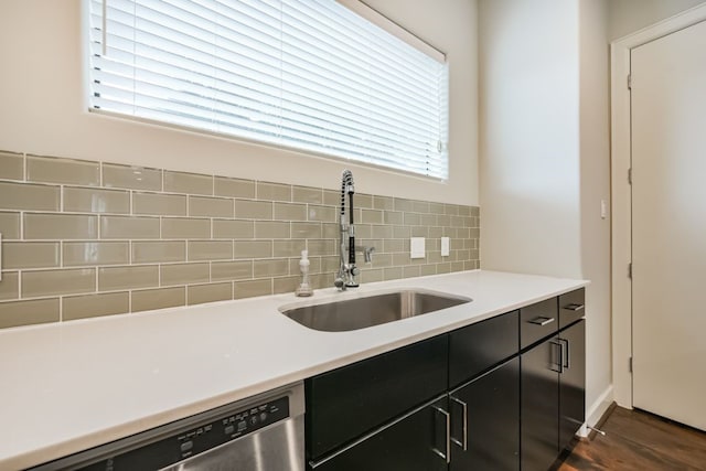 kitchen with tasteful backsplash, dishwasher, dark wood-type flooring, and sink