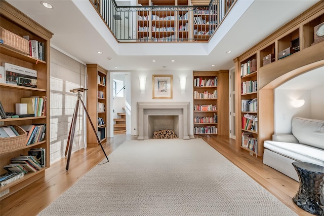 living area with a towering ceiling and light hardwood / wood-style floors