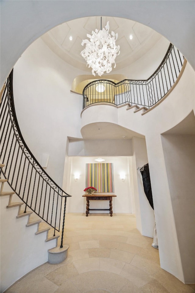 stairway with a notable chandelier and a high ceiling