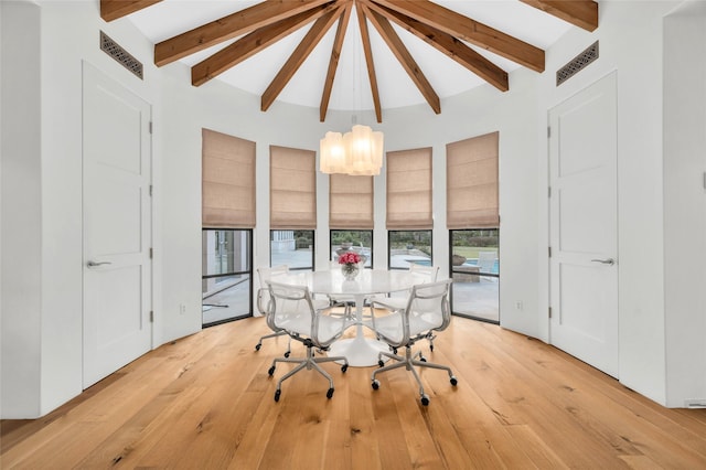 dining room with beamed ceiling and light hardwood / wood-style floors