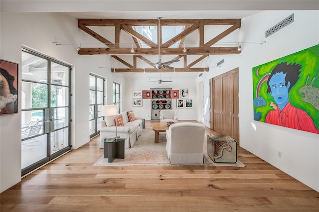 living room featuring ceiling fan, beam ceiling, high vaulted ceiling, and light hardwood / wood-style flooring