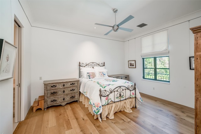 bedroom with ceiling fan, light hardwood / wood-style floors, and ornamental molding