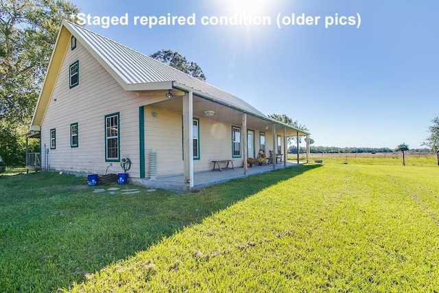 view of side of property with metal roof and a yard