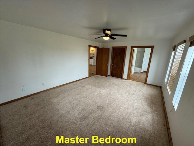 unfurnished bedroom featuring carpet floors, a ceiling fan, and baseboards