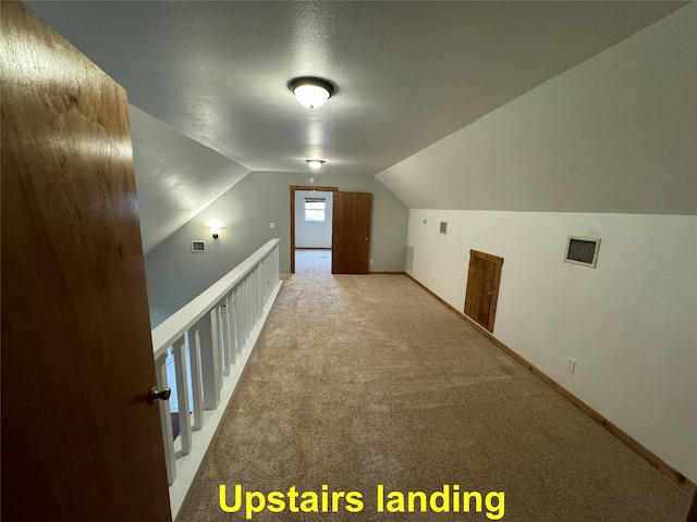 additional living space featuring vaulted ceiling, carpet, visible vents, and baseboards