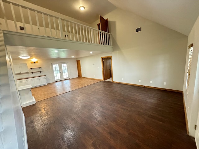 unfurnished living room featuring french doors, dark wood finished floors, visible vents, and baseboards