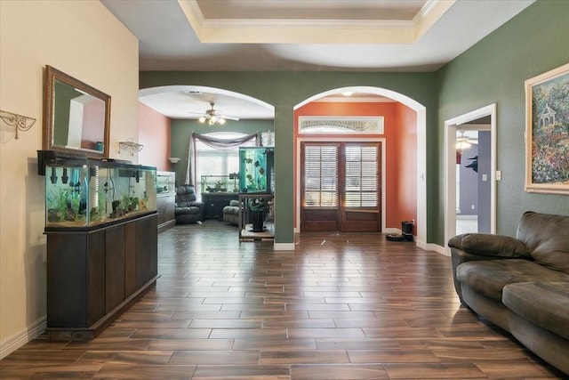 entrance foyer with ceiling fan and a tray ceiling