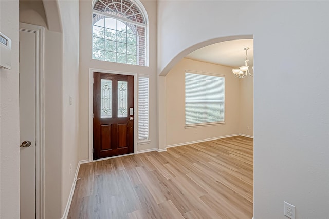 foyer entrance with light wood-type flooring and a notable chandelier