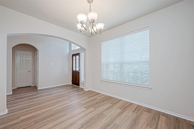 foyer entrance with a notable chandelier and light wood-type flooring