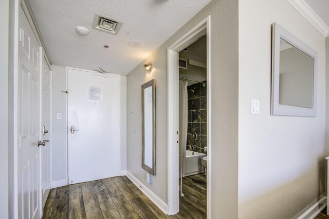 hallway with a textured ceiling, dark hardwood / wood-style flooring, and crown molding