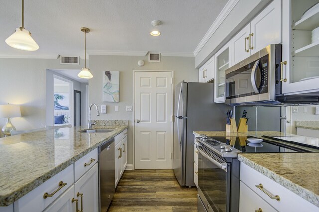 kitchen featuring light stone counters, ornamental molding, stainless steel appliances, sink, and white cabinets