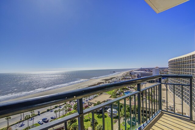 balcony featuring a water view and a beach view