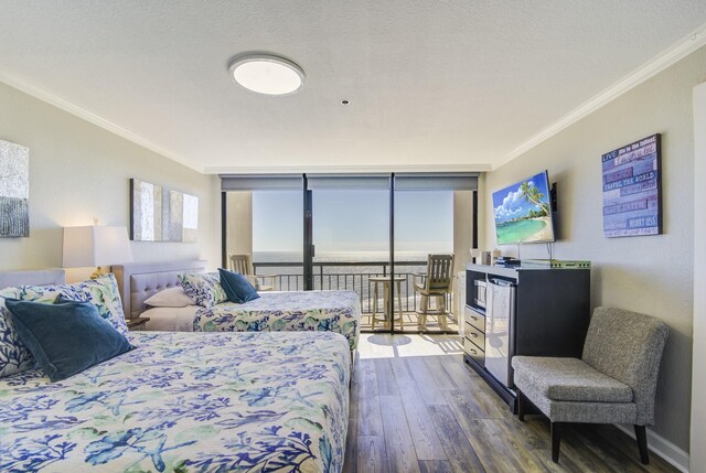 bedroom with access to exterior, expansive windows, ornamental molding, a textured ceiling, and dark hardwood / wood-style floors