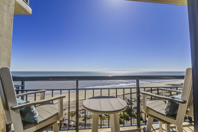 balcony with a beach view and a water view