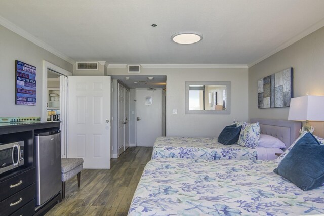 bedroom with crown molding, dark hardwood / wood-style flooring, and fridge