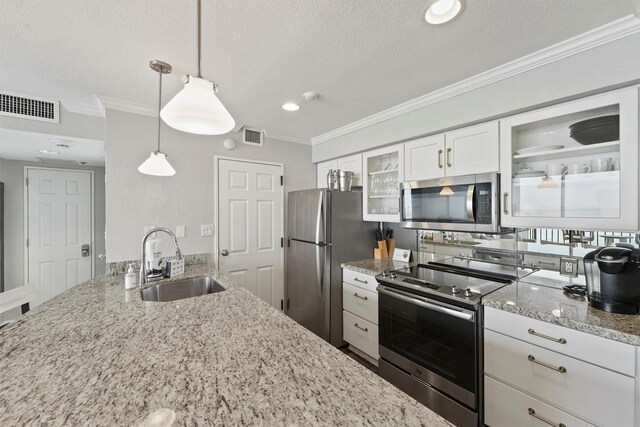 5220 Seawall Blvd Unit 1536/37, Galveston, TX 77551 - kitchen with appliances with stainless steel finishes, a textured ceiling, light stone countertops, glass insert cabinets, and white cabinetry