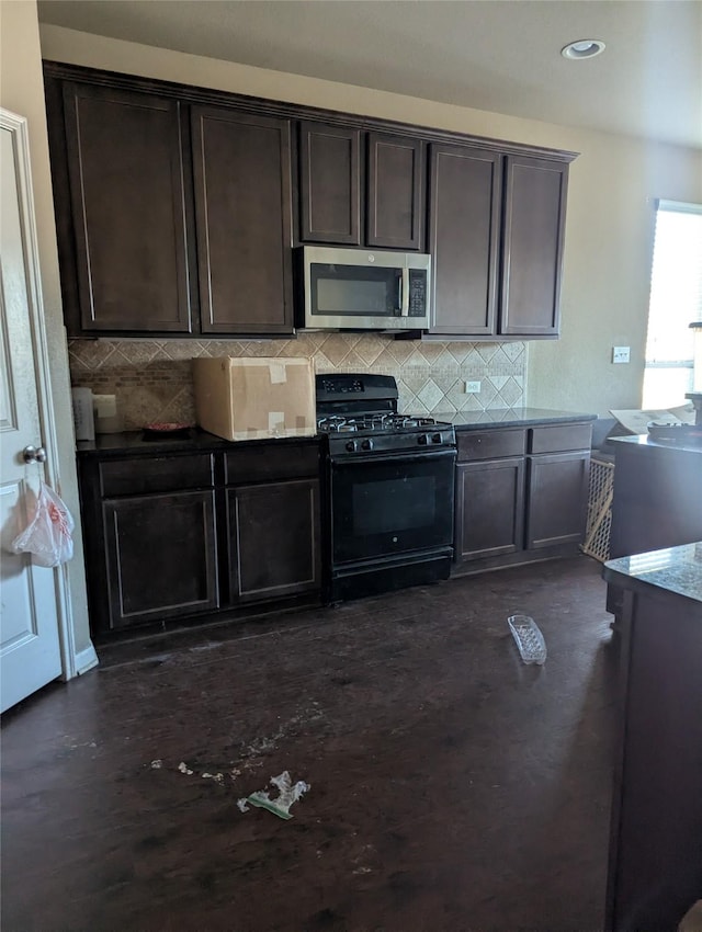 kitchen featuring dark brown cabinets, gas stove, and backsplash